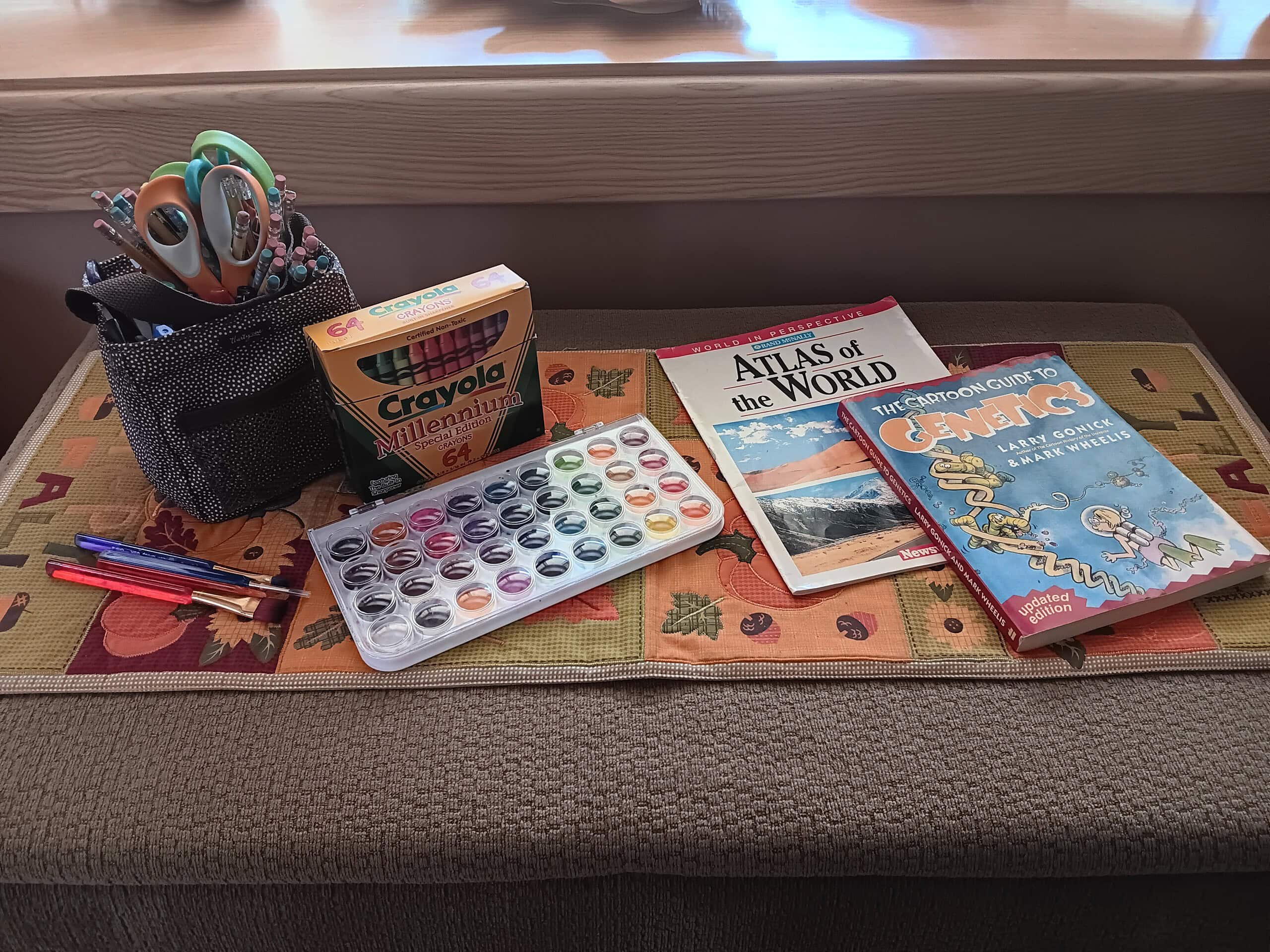 Strewing Ideas: Textbooks, Watercolor Paints, Crayons, Paintbrushes and a Basket of Pencils